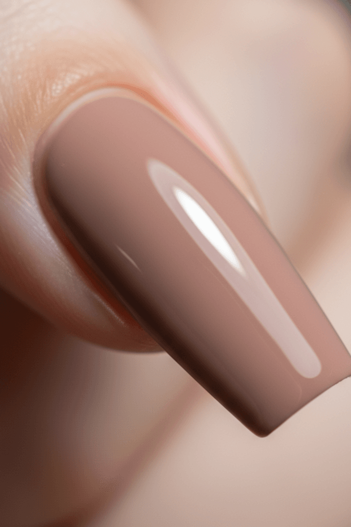 High-resolution micro-photography of a coffin-shaped nail enhancement in deep nude gel polish, showing the crisp tapered sides and flat, squared-off free edge.